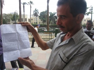 Khaled El Sayed holds up his complaint asking for a kiosk license  Sarah Mohy El-Masry