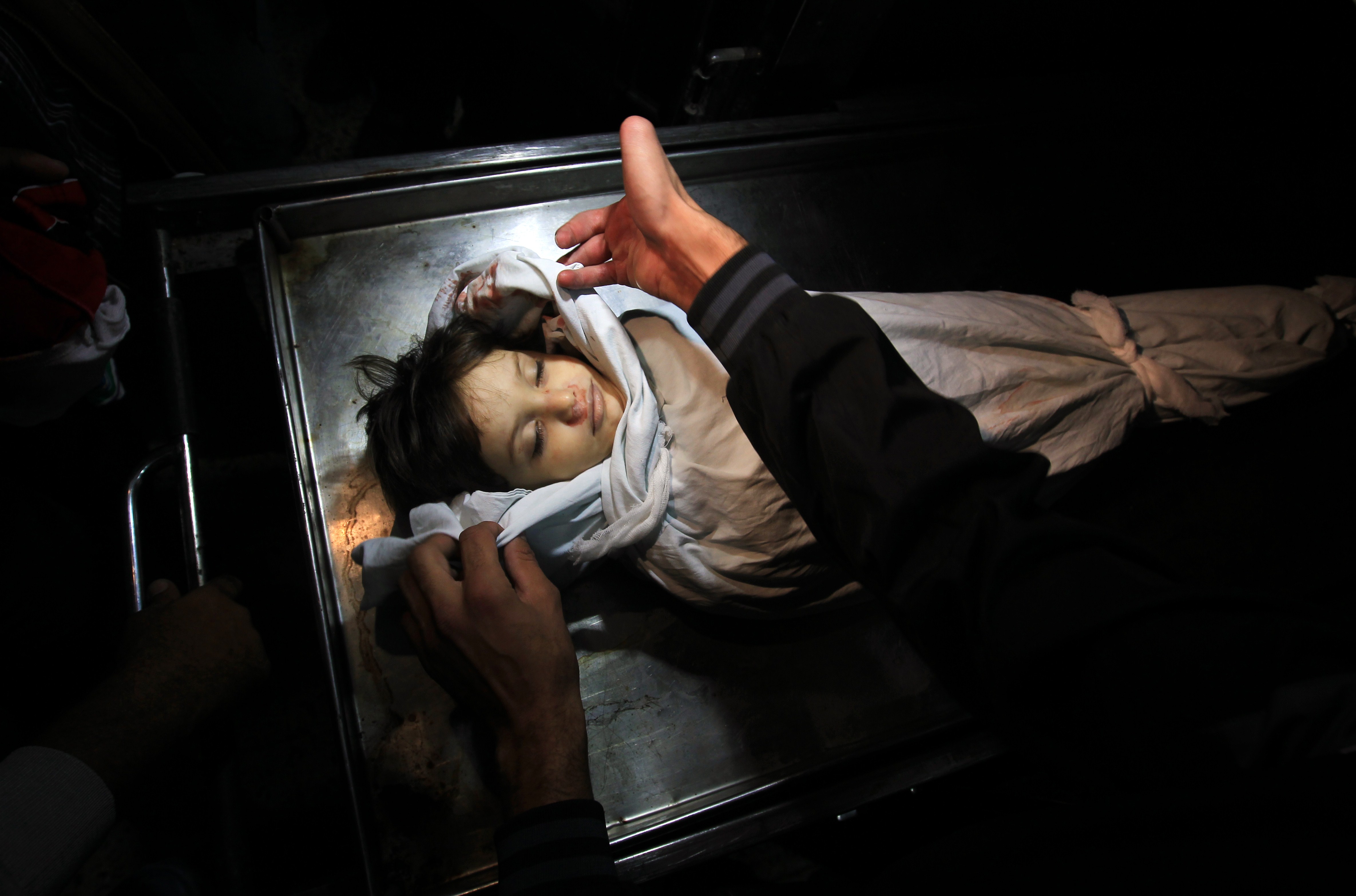 he body of Palestinian boy Abdel Rahman Majdi Naim lies in a hospital morgue after he was killed in a second Israeli strike on the building housing AFP's offices in Gaza city, according to Hamas health officials, on 21 November. (AFP PHOTO / MAHMUD HAMS)