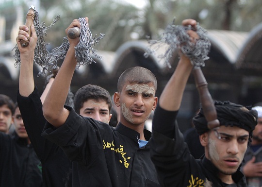 Smeared with mud, Shiite Muslim pilgrims beat themselves with metal chains as they take part in a parade in preparation for the peak of the Ashura ceremony, near the shrine of Imam Hussein in Karbala, some 80 kilometers (50 miles) southwest of Baghdad, on 24 November. (AFP PHOTO / AHMAD AL-RUBAYE)