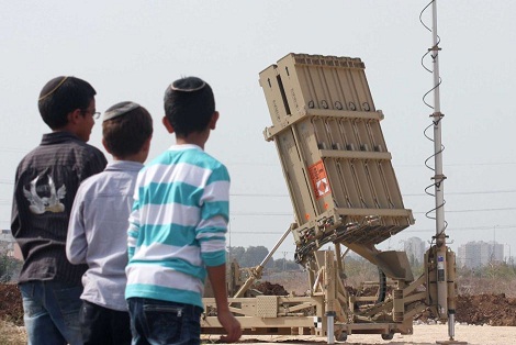 Israeli children look at the Israeli military's Iron Dome defence missile system, designed to intercept and destroy incoming short-range rockets and artillery shells, deployed in Gush Dan, the Tel Aviv metropolitan area, 17 November. (AFP / Roni Schutzer)