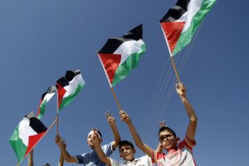 Palestinian children wave their national flag. (AFP PHOTO / GETTY IMAGES / MUSA AL-SHAFER)