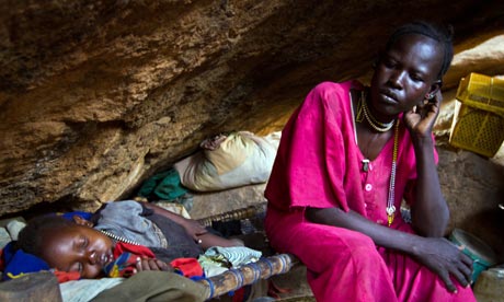 A mother and child rest in a cave in South Kordofan, Sudan. They are among thousands of civilians sheltering from aerial bombing. (AFP / GETTY IMAGES)