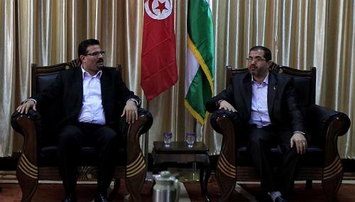 Tunisian Foreign Minister Rafik Abdessalem (left) meets with senior Palestinian Hamas member Bassem Naim upon arrival in Rafah through the border crossing between Egypt and the southern Gaza Strip on 17 November. (AFP PHOTO)