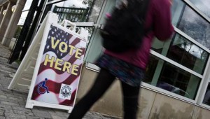A woman walks past a sign at an early voting centre in Washington on Oct 31, 2012. (AFP PHOTO)
