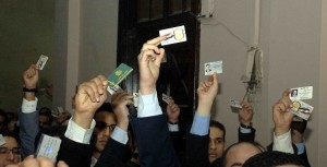 Protesters wave their membership cards in the air during a protest demanding the resignation of the prosecutor general. (DNE/ Mohamed Omar) 