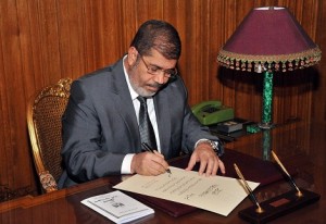 President Morsy signs into law the new constitution at his office in the presidential. (AFP File Photo / HO / Egyptian Presidency) 