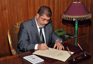 President Morsy signs into law the new constitution at his office in the presidential. (AFP Photo / HO / Egyptian Presidency) 