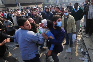 A protester overcome by teargas is carried off to a field hospital on Mohamed Mahmoud Street in December 2012 (DNE File Photo/ Hassan Ibrahim)