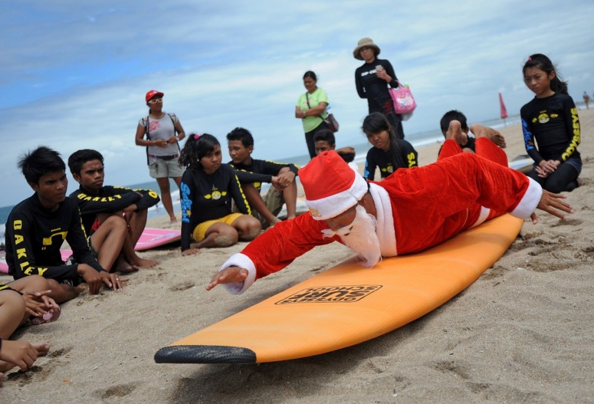 A Balinese surfer dressed in a Santa Claus outfit trains children before their surf outing on Kuta beach near Denpasar on Indonesia's resort island of Bali. The popular resort island is a pocket of Hindu culture in a country with the biggest Muslim population in the world receiving thousands of tourists every year over the Christmas season. AFP Photo / Sonny Tumbelaka