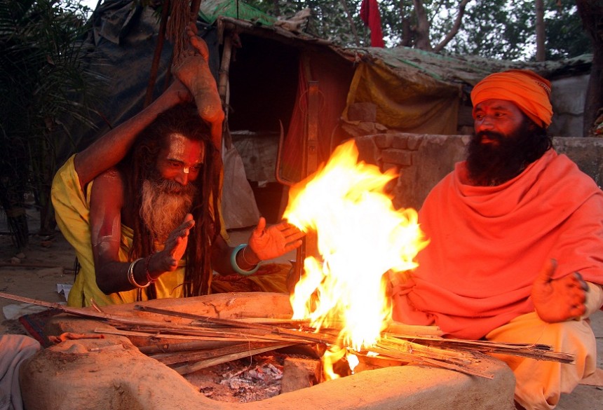 Indian Sadhus keep warm by a fire and do yoga at their camp on the bank of “Sangam” the confluence of the three rivers Ganges Yamuna and Saraswati in Allahabad ahead of the Mahakumbh Mela festival. AFP Photo / Sanjay Kanojia