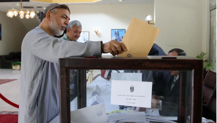 An Egyptian man living in Oman casts his vote on the draft constitution in Egypt at the Egyptian embassy in the Gulf sultanate's capital Muscat on 12 December (AFP Photo)