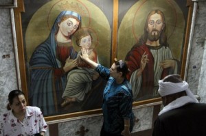 An Egyptian Christian Copt touches the image of Jesus Christ during Sunday mass in Cairo, in September 2012 (AFP/File, Maher Iskandar)