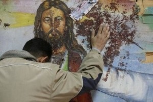 An Egyptian Christian mourns as he stands next to a blood-stained painting of Jesus Christ at the Al-Qiddissine (The Saints) church in Alexandria. (AFP/Mohammed Abed)