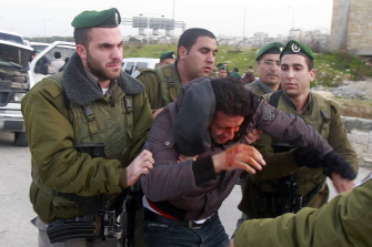 Israeli border policemen arrest a Palestinian man at the entrance of the village of Zayem, as he was on his way to join an "outpost" named Bab al-Shams ("Gate of the Sun") between Jerusalem and the Jewish settlement of Maale Adumim in the Israeli-occupied West Bank, in an area where Israel has vowed to build new settler homes, on January 12, 2013. Israeli authorities quickly issued expulsion orders, but activists' lawyers successfully petitioned the supreme court at night for a stay. TOPSHOTS/AFP PHOTO/MUSA AL SHAER