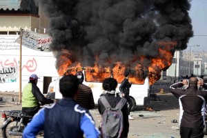 Smoke billows from a burning minibus belonging to a satellite channel after it was set on fire by Egyptian protesters outside the Port Said prison in the Egyptian canal city on 26 January. (AFP PHOTO / STR)