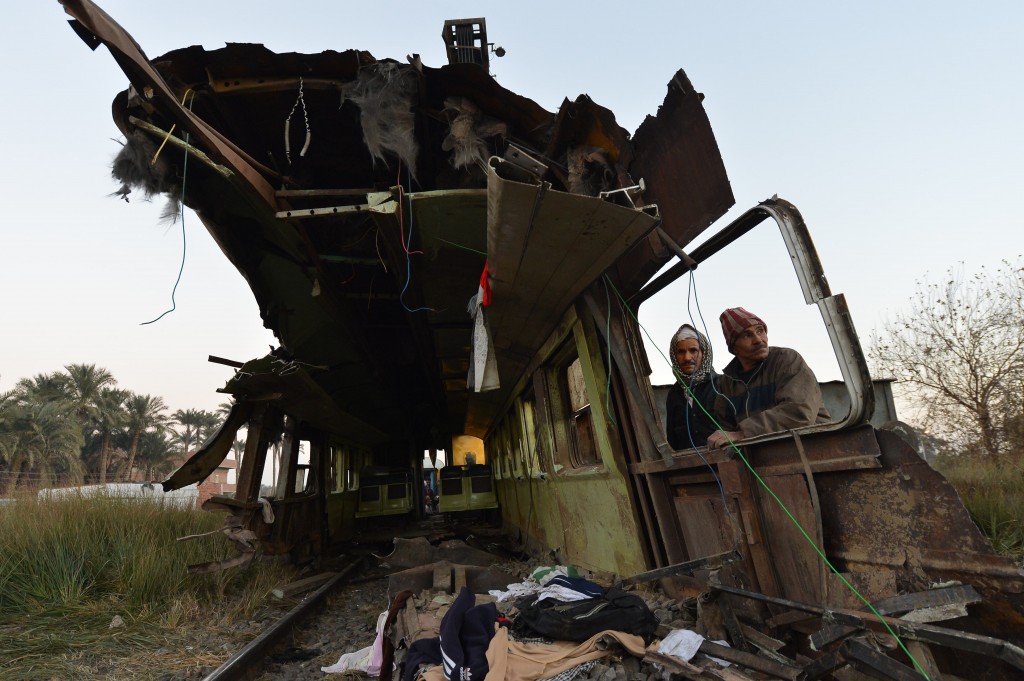 Egyptian workers remove the wreckage of a train in the Giza in Badrashein where at least 19 people were killed and injured 105.  (AFP Photo / Khaled Desouki)