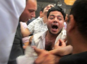 Al-Walid Ismael is involved in scuffles with pro-Mubarak supporters during the trial of the former president. (Photo via Al-Walid Ismael Facebook page)