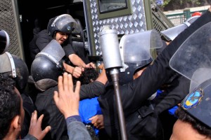 Security forces pull an arrested man into the back of a police van near Tahrir Square.(DNE/ Mohamed Omar)