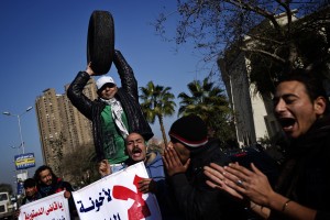An Egyptian opposition protester holds a tyre symbolizing President Mohamed Morsy's nickname "spare tyre" during a gathering in front of the Supreme Constitutional . (AFP Photo / Gianluigi Guercia)