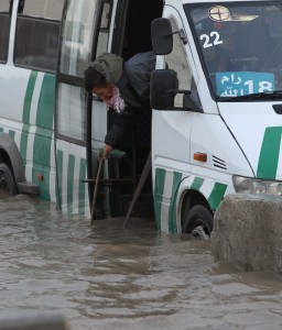 4-3 A man checks the level of the water in a flooded street in front of the Israeli separation barrier at the Qalandia checkpoint in the Israeli occupied West Bank, on 7 January. (AFP PHOTO/ABBAS MOMANI)