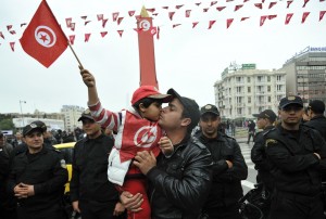A Tunisian kisses a boy holding a national flag during festivities to mark the second anniversary of the uprising that ousted long-time dictator Zine El Abidine Ben Ali. (AFP Photo / Fethi Belaid)