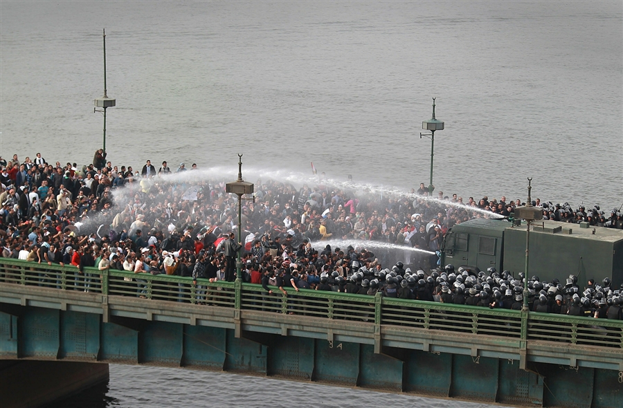 Riot police fire water cannons at protesters attempting to cross the Qasr Al Nile Bridge in downtown Cairo AFP Photo / Peter Macdiarmid