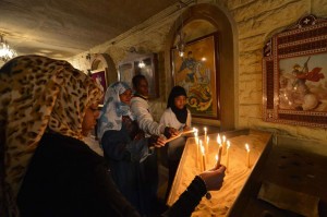 Members of an Egyptian Muslim family light candles at a Coptic Christian church on 6 January in the historical centre of Cairo. (AFP Photo / Khaled Desouki)