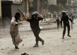 A riot policeman hits a protester during clashes near Tahrir Square AFP Photo / Mohammed Abed