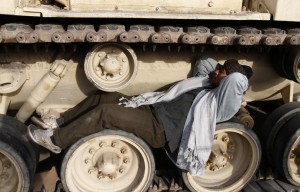 An Egyptian pro-democracy demonstrator sleeps on the wheels of a military vehicle in Tahrir square on 6 February  (AFP Photo)