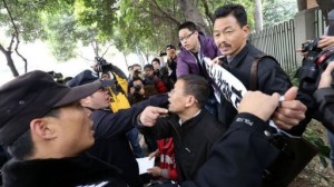 Police remove banners from protesters demanding greater media freedom, during a rally in Guangzhou on 9 January 2013 (AFP)