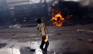 An Egyptian demonstrator throws a fuel bomb at police vehicles  (AFP Photo)