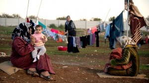 Mothers and their children sit among their washing in a refugee camp on the border between Syria and Turkey near the northern city of Azaz on Dec. 5, 2012. (ODD ANDERSEN/AFP/Getty Images)
