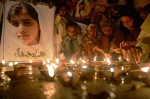 Pakistani children place oil lamps next to a photograph of activist Malala Yousafzai in Karachi on October 12, 2012 (AFP/File, Asif Hassan)