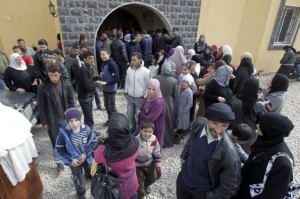 Syrian refugees wait for their turn to receive humanitarian aid at the entrance of an NGO in the area of Wadi Khaled on the Lebanese-Syrian border northern Lebanon. (AFP Photo)