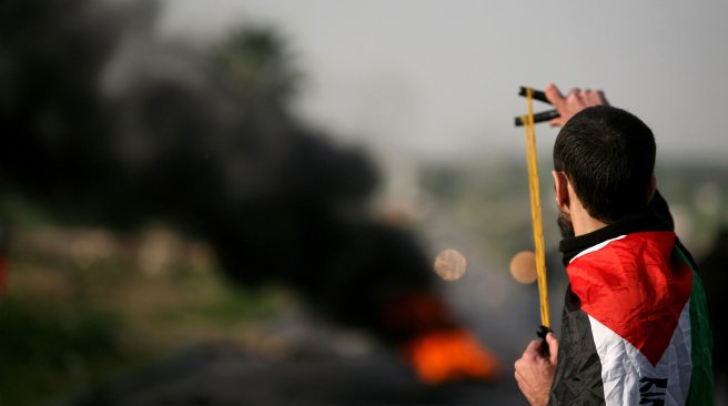 A Palestinian protestor aims his slingshot at Israeli police during clashes at the entrance of the Jalama checkpoint, near the West Bank city of Jenin, on February 22, 2013. AFP PHOTO
