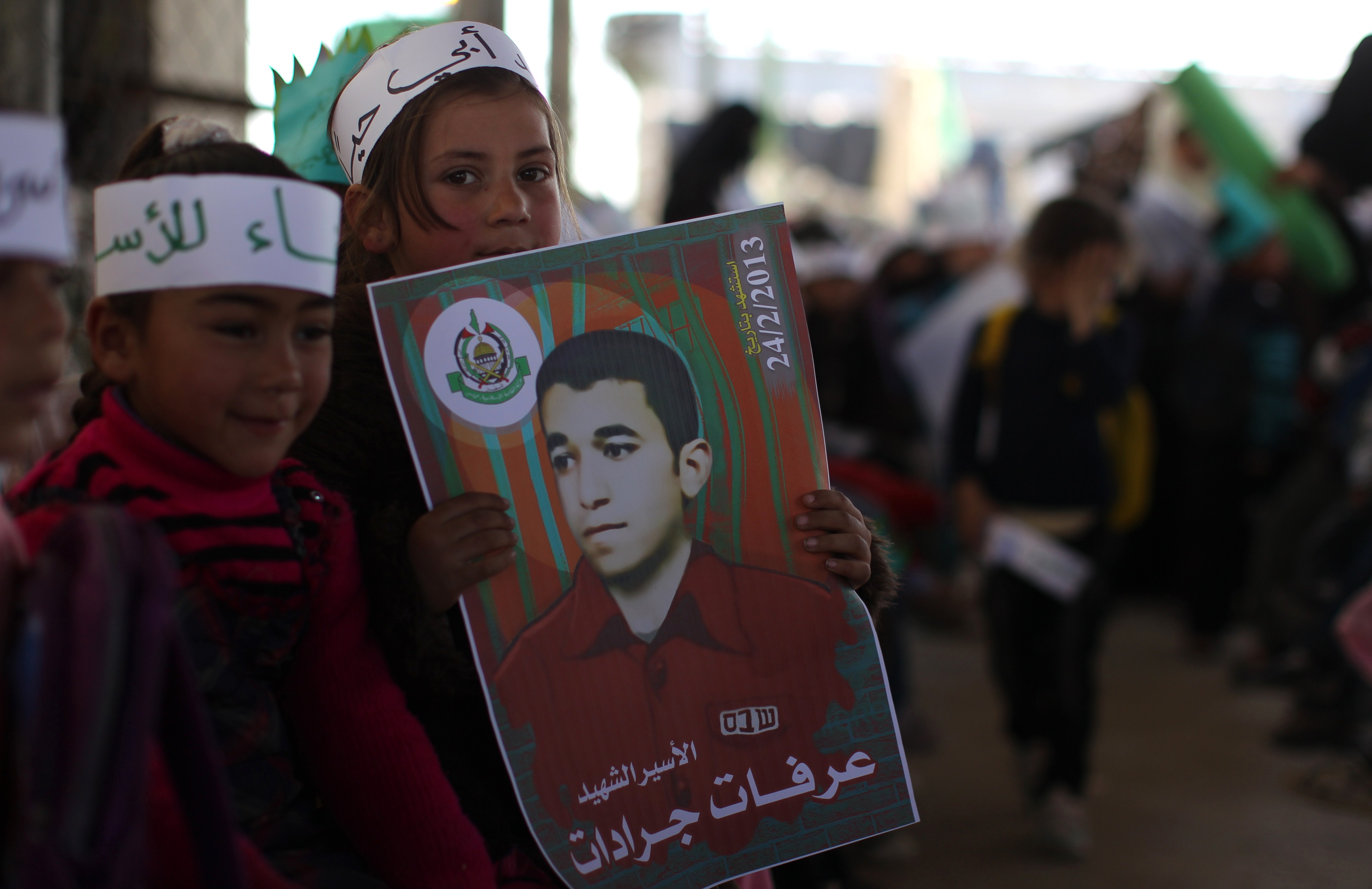 A Palestinian girl carries a poster of Arafat Jaradat, who died in an Israeli prison, during a protest at Erez border crossing between Israel and the northern Gaza Strip on (AFP Photo)