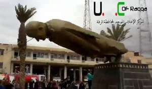 An image grab taken from a video uploaded on YouTube shows Syrian anti-regime protesters destroying a statue of former president Hafez al-Assad after rebels overran the northern city of Raqqa (AFP Photo\ Youtube)