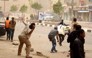 Egyptian protesters throw stones towards riot police during clashes in the street that leads to the headquarters of the Muslim brotherhoods in Cairo (AFP Photo)