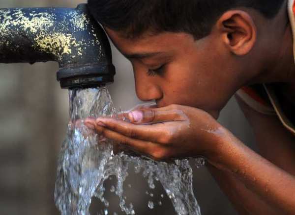 child drinks water from a ha