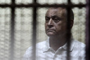 Former Egyptian housing minister Mohammed Ibrahim Suleiman stands behind bars during his hearing at a court in Cairo on August 27, 2011. Following the ouster of former Egyptian president Hosni Mubarak, several of his ministers and deputies have been hauled into court most on corruption charges.  (AFP File Photo)