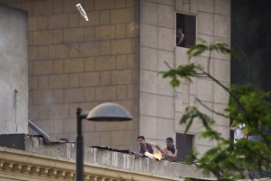 Unidentified protesters throw a molotov cocktail towards Egyptian riot police from the roof of St. Mark Coptic cathedral in Cairo's Abbassiya on 7 April (AFP Photo/Gianluigi Guercia) 