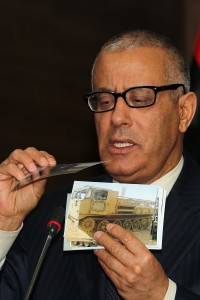 Libyan Prime minister Ali Zeidan shows photos of weaponry and vehicles retrieved from various brigades and militias as he gives a press briefing on the Libyan security situation on April 8, 2013 in Tripoli. Gunmen posing as security personnel kidnapped a top aide of Libyan Prime Minister Ali Zeidan, just hours after the premier revealed members of his government had received death threats, a cabinet source told AFP