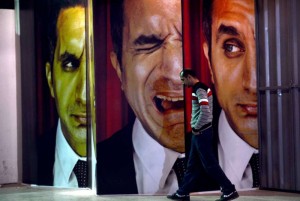 An Egyptian walks past posters of Egyptian satirist Bassem Youssef outside a theatre in Cairo (AFP File Photo)