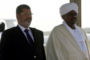 Sudanese President Omar al-Bashir (R) and Egyptian counterpart Mohamed Morsi listen to their national anthems during a departure ceremony at Khartoum airport on April 5, 2013 (AFP Photo)