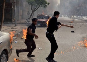 Two men try to put out their burning clothes after they were attacked by unidentified individuals outside the cathedral in the central Cairo neighbourhood of Abbassiya on April 7, 2013, following funeral prayers for four Christians killed in sectarian clashes (AFP Photo)