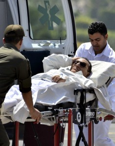 Ousted Egyptian president Hosni Mubarak (C) is wheeled out of an ambulance outside the Maadi military hospital following a hearing in Cairo on April 13, 2013.  (AFP Photo)