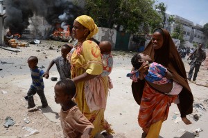 Two mothers run with their children on April 14, 2013, in Mogadishu, after a suicide bomber attack in the regional court premises that left several dead. (AFP Photo)