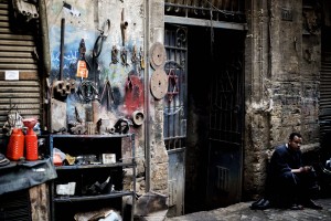 An Egyptian shoeshiner works near a gate ornamented with a Star of David in a narrow street, known as the Jewish Street in the old part of Cairo. (AFP Photo)