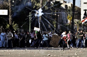 Muslim Brotherhood movement's supporters throw stones towards opponents of the movement during clashes on April 19, 2013 in central Cairo. during the march outside the Supreme Court in central Cairo demanding judicial reform