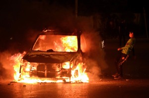 An Egyptian child kicks a burning police van after unknown attackers torched it during clashes outside the Egyptian presidential palace on April 26, 2013 in Cairo, Egypt (AFP Photo)